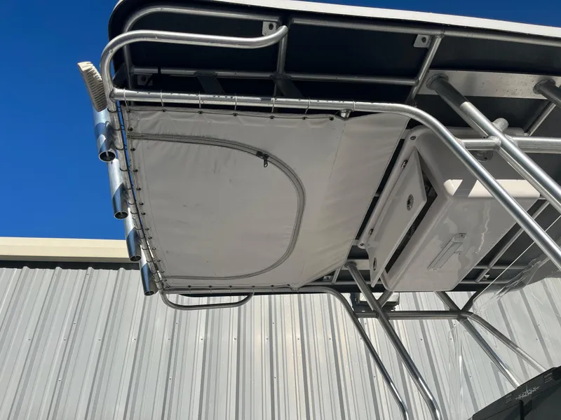 Slide: The Image of 2003 Pro-Line 25 Sport CC boat with T-top and rod holders against blue sky. - 27