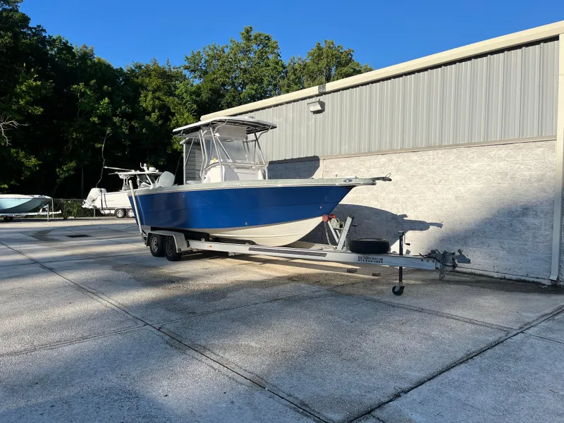 Slide: The Image of 2003 Pro-Line 25 Sport CC boat on trailer, parked outdoors near a building. - 3