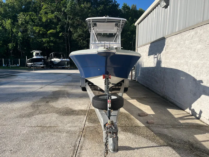 Slide: The Image of 2003 Pro-Line 25 Sport CC boat on trailer, parked outdoors near a building. - 4