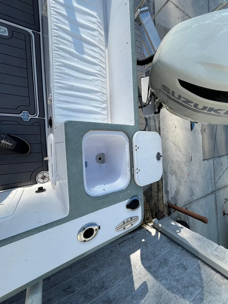 Slide: The Image of 2003 Pro-Line 25 Sport CC boat deck with Suzuki engine and storage compartments. - 5