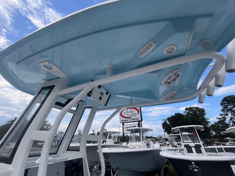 Slide: The Image of 2023 Tidewater 232 CC Adventure boat with T-top and speakers, displayed at a marine dealership. - 11