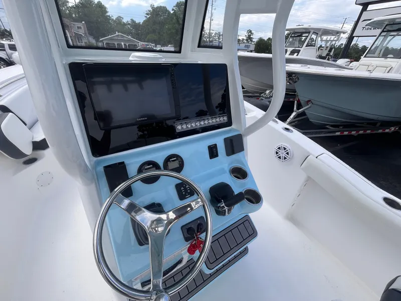 Slide: The Image of 2023 Tidewater 232 CC Adventure boat dashboard with steering wheel and navigation display. - 12
