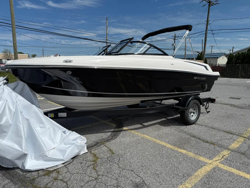 The Image of 2025 Bayliner VR4 Bowrider I/O boat on trailer in parking lot. - 1