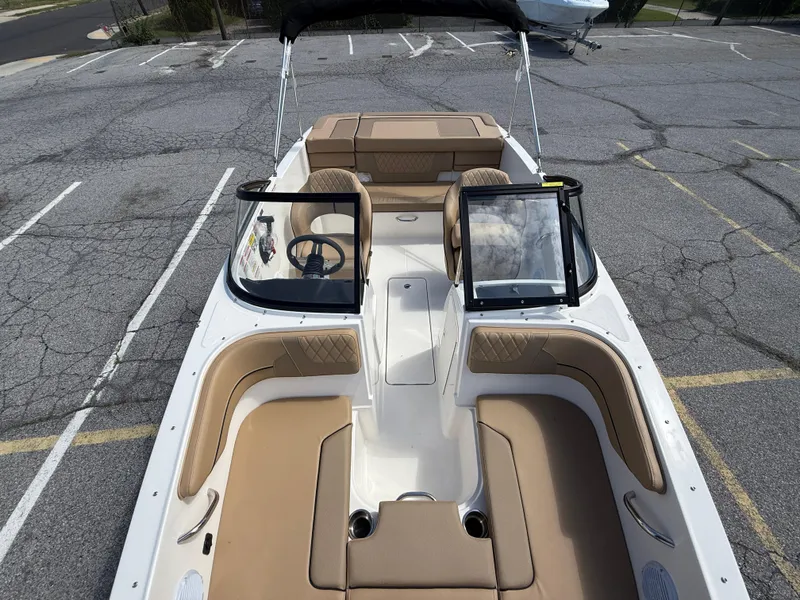 Slide: The Image of 2025 Bayliner VR4 Bowrider I/O with tan interior, parked on cracked pavement. - 13