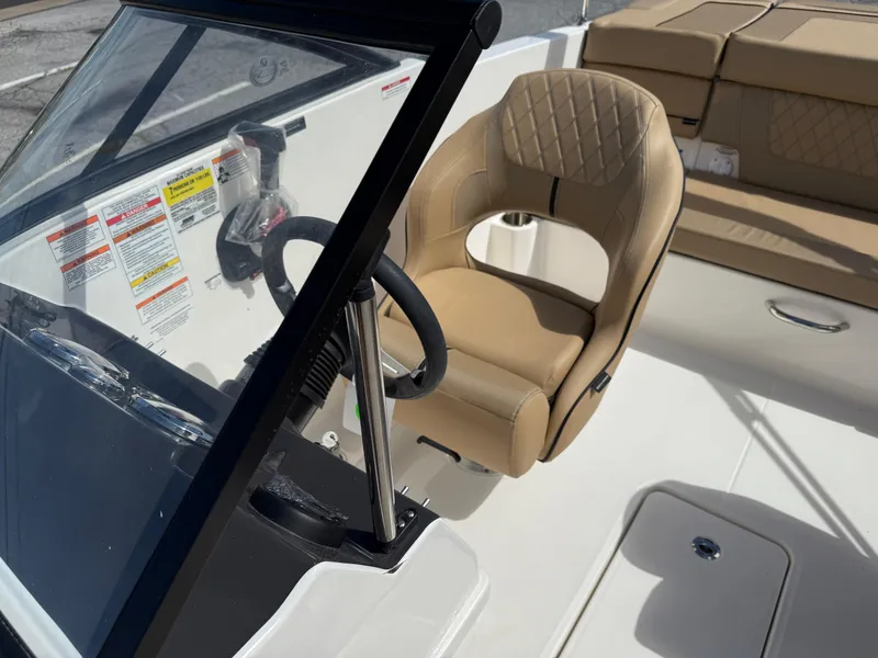 Slide: The Image of 2025 Bayliner VR4 Bowrider I/O interior with tan seating and steering wheel. - 6