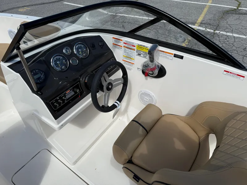 Slide: The Image of 2025 Bayliner VR4 Bowrider I/O dashboard and seating area, featuring modern controls and comfortable seating. - 7