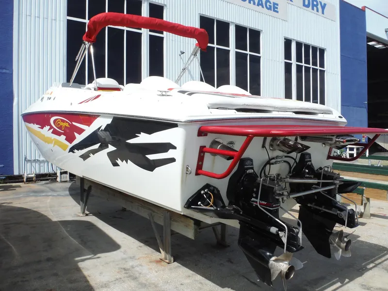 Slide: The Image of 2003 Baja 36 Outlaw speedboat with vibrant graphics, docked near a storage facility. - 10