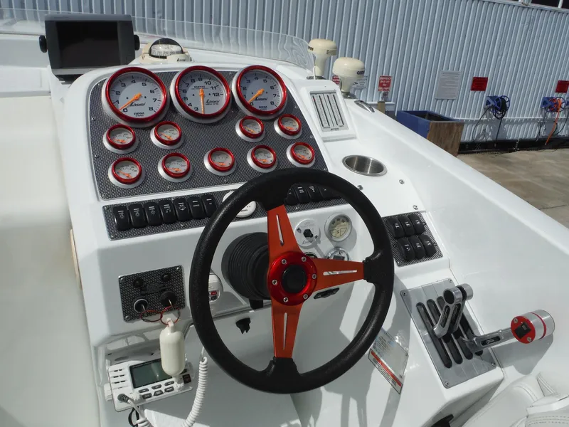 Slide: The Image of 2003 Baja 36 Outlaw boat dashboard with gauges, steering wheel, and controls. - 14