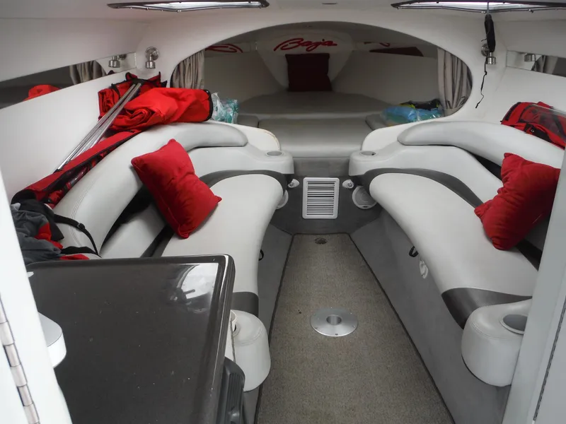 Slide: The Image of 2003 Baja 36 Outlaw boat interior with white seating, red cushions, and modern design. - 22