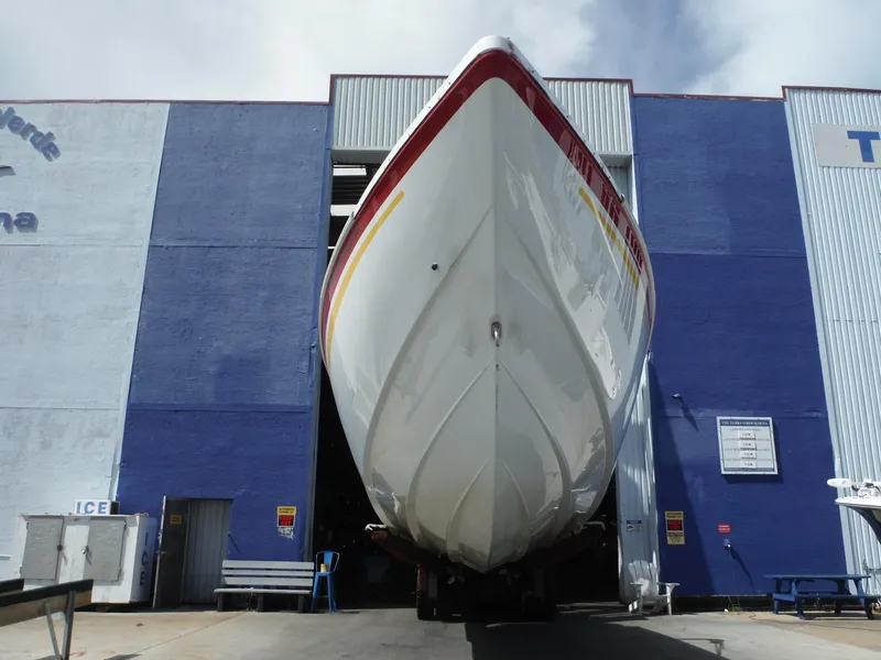 Slide: The Image of 2003 Baja 36 Outlaw boat in dry dock, viewed from below, against a blue building backdrop. - 3