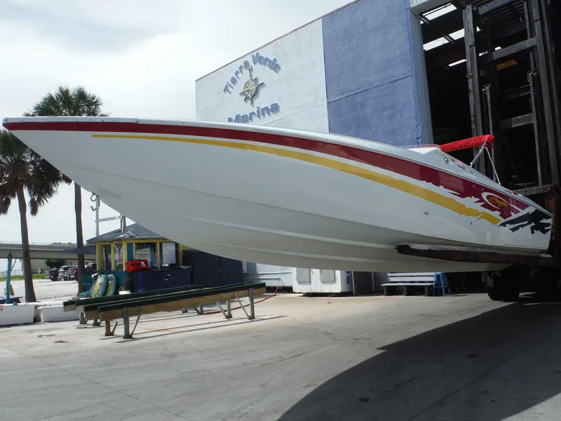 Slide: The Image of 2003 Baja 36 Outlaw speedboat in dry dock, featuring vibrant red and yellow graphics. - 4