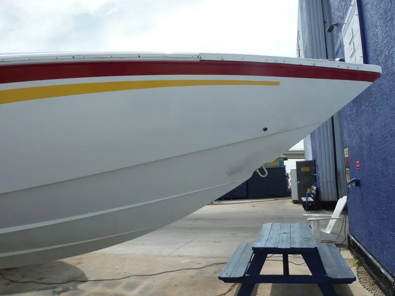 Slide: The Image of 2003 Baja 36 Outlaw boat bow with red and yellow stripes, dockside view. - 45