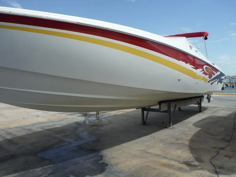 Slide: The Image of 2003 Baja 36 Outlaw boat on dry dock, showcasing sleek design and vibrant colors. - 46