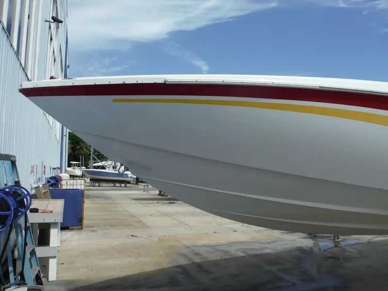 Slide: The Image of 2003 Baja 36 Outlaw boat in dry dock, showcasing sleek hull design. - 47