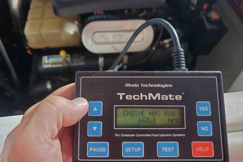 Slide: The Image of Hand holding TechMate device showing engine runtime of 660.1 hours on 2003 Baja 36 Outlaw. - 55