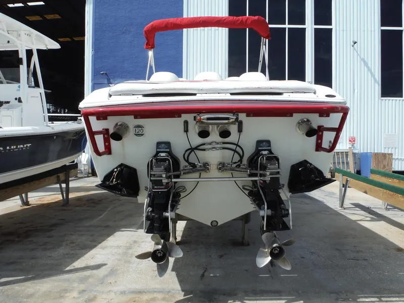 Slide: The Image of 2003 Baja 36 Outlaw boat rear view with dual propellers in a marina setting. - 7