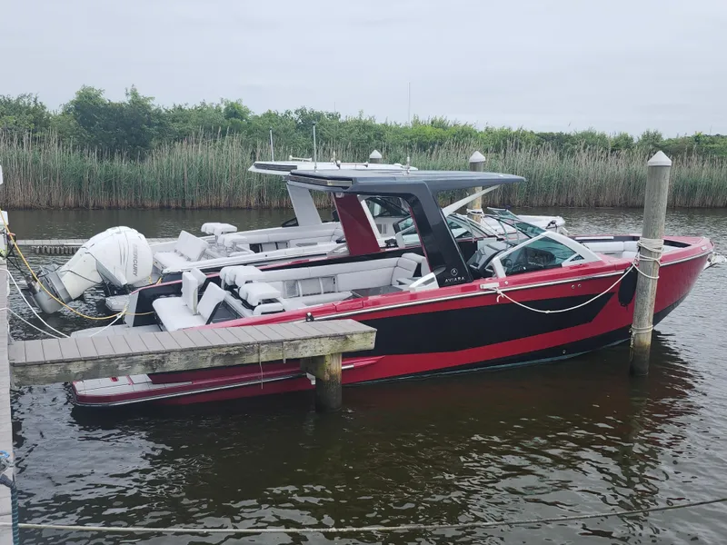 The Image of 2020 Aviara AV32 I/O boat docked, featuring sleek red and black design. - 0