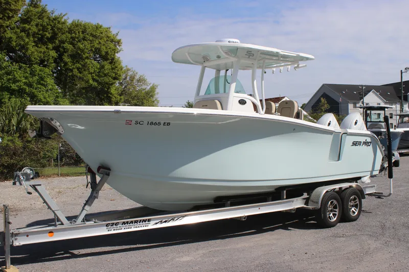 The Image of 2023 Sea Pro 259 Deep V CC boat on trailer, parked outdoors. - 1