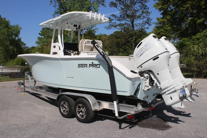 Slide: The Image of 2023 Sea Pro 259 Deep V CC boat on trailer with dual Suzuki engines. - 2