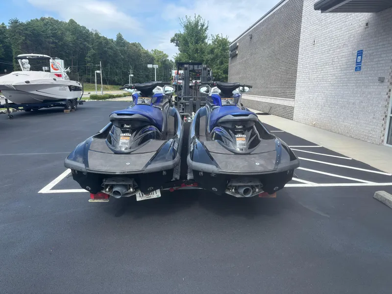 Slide: The Image of Two 2006 Yamaha WaveRunner FX HO jet skis parked on asphalt near a building. - 2