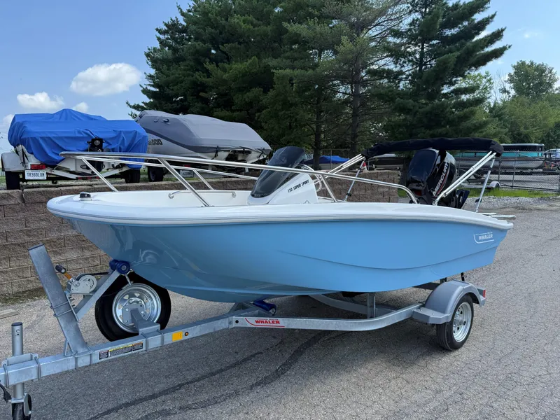 The Image of 2025 Boston Whaler 130 Super Sport boat on trailer, parked outdoors. - 0