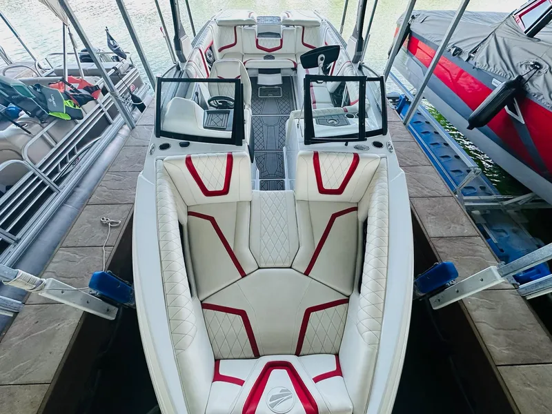 Slide: The Image of 2020 Tigé 25ZX boat interior with white and red seating, docked at marina. - 16