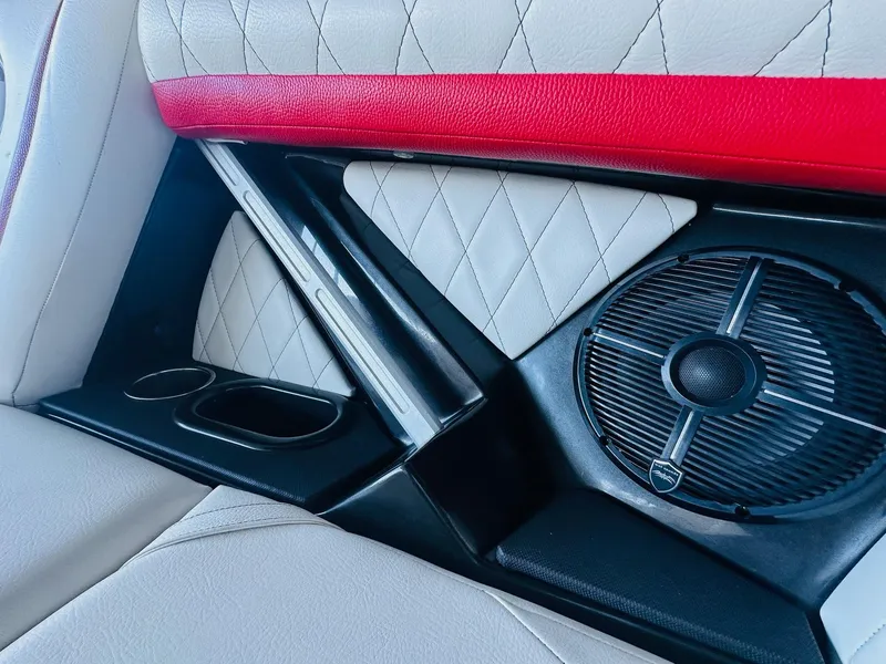 Slide: The Image of 2020 Tigé 25ZX interior with red and white upholstery, speaker, and cup holders. - 22