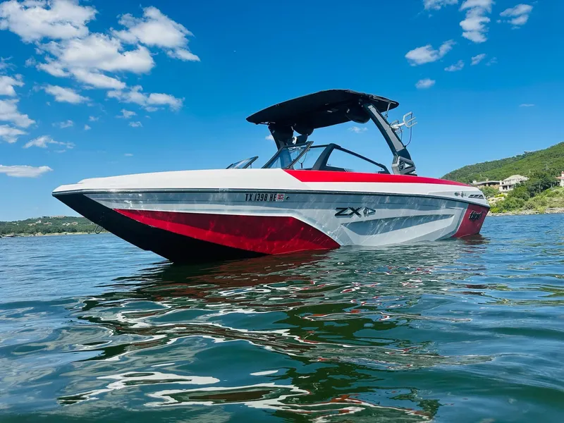 Slide: The Image of 2020 Tigé 25ZX boat on water under clear blue sky. - 5