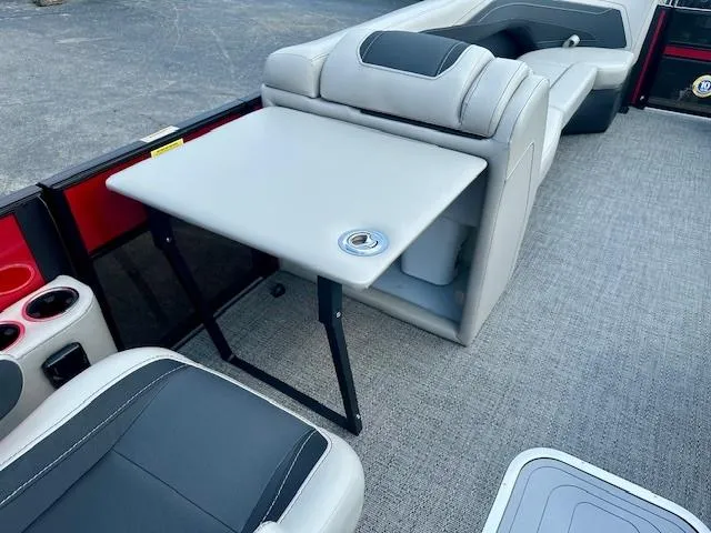 Slide: The Image of 2026 Barletta C24UC boat interior with gray seating and foldable table. - 13