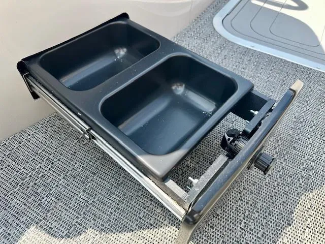 Slide: The Image of Barletta C24UC 2026 boat with dual-compartment storage tray on textured flooring. - 16