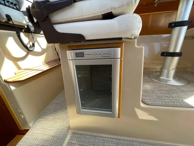 Slide: The Image of Captain's chair and Dometic fridge in 2017 Cutwater C-28 boat interior. - 12
