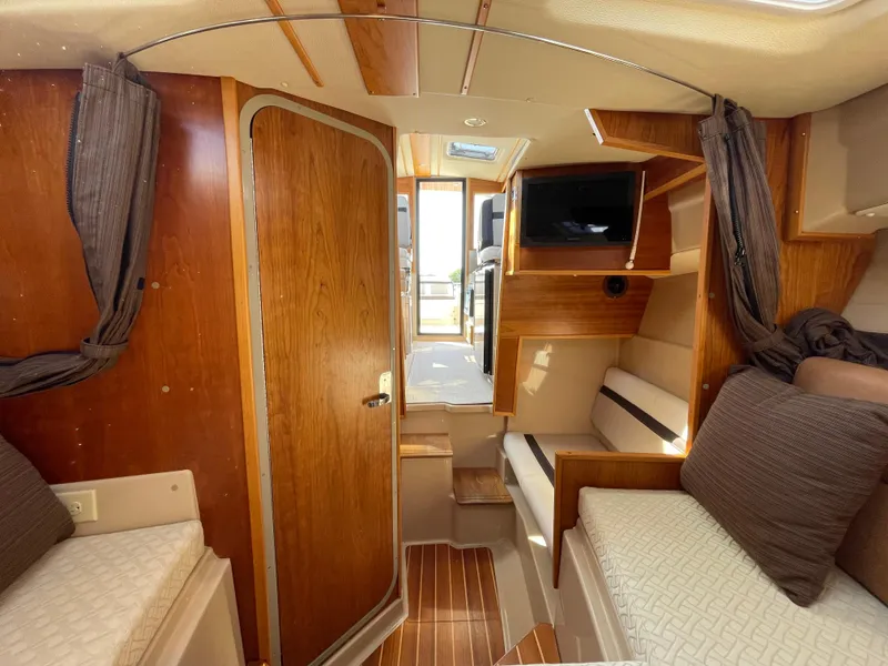 Slide: The Image of 2017 Cutwater C-28 cabin interior with wood finish, seating, and TV. - 16