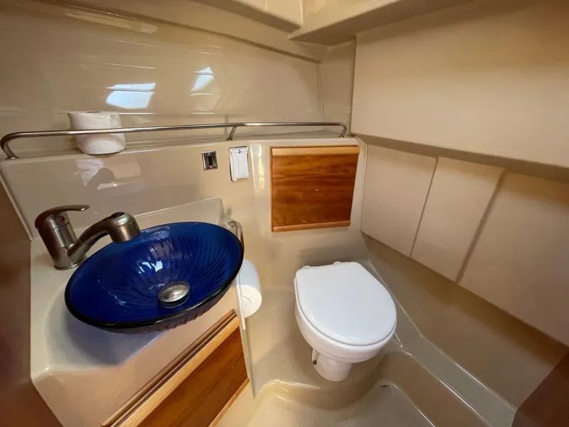 Slide: The Image of 2017 Cutwater C-28 boat bathroom with blue glass sink and modern fixtures. - 17