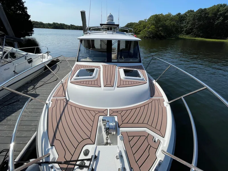 Slide: The Image of 2017 Cutwater C-28 boat docked on a serene lake with lush greenery. - 3