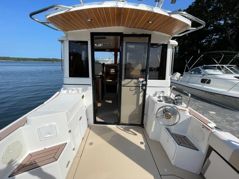 Slide: The Image of 2017 Cutwater C-28 boat cockpit with seating, steering wheel, and water view. - 5