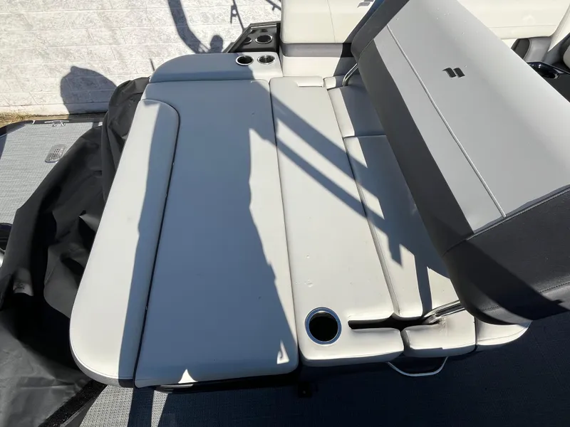 Slide: The Image of 2025 Starcraft EXS-3 boat seating area with cup holders, featuring light gray upholstery. - 12