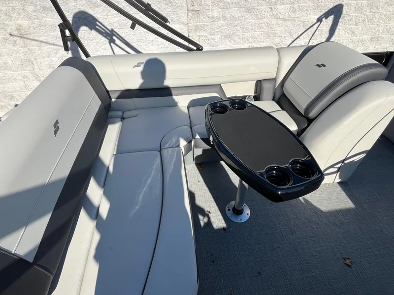 Slide: The Image of Luxurious seating area on 2025 Starcraft EXS-3 boat with table and cup holders. - 13