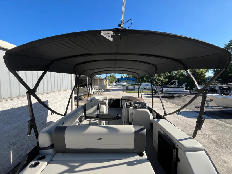 Slide: The Image of 2025 Starcraft EXS-3 boat interior with canopy, parked outdoors under clear blue sky. - 32