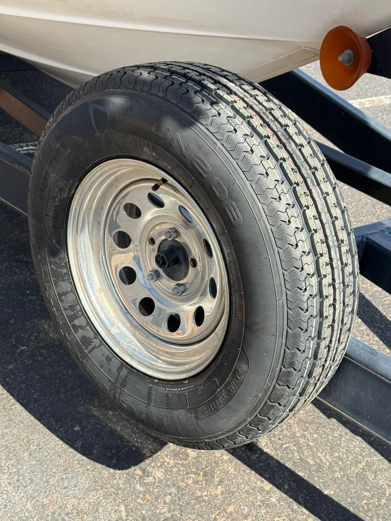 Slide: The Image of Trailer tire for 2001 Sea Ray 270 Sundancer boat on pavement. - 11