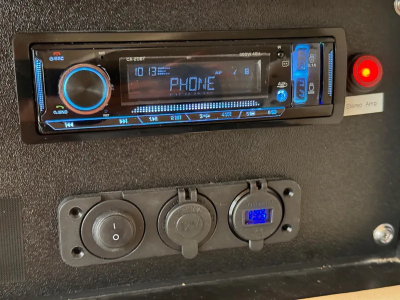 Slide: The Image of 2001 Sea Ray 270 Sundancer stereo system with phone connectivity and power outlets. - 17