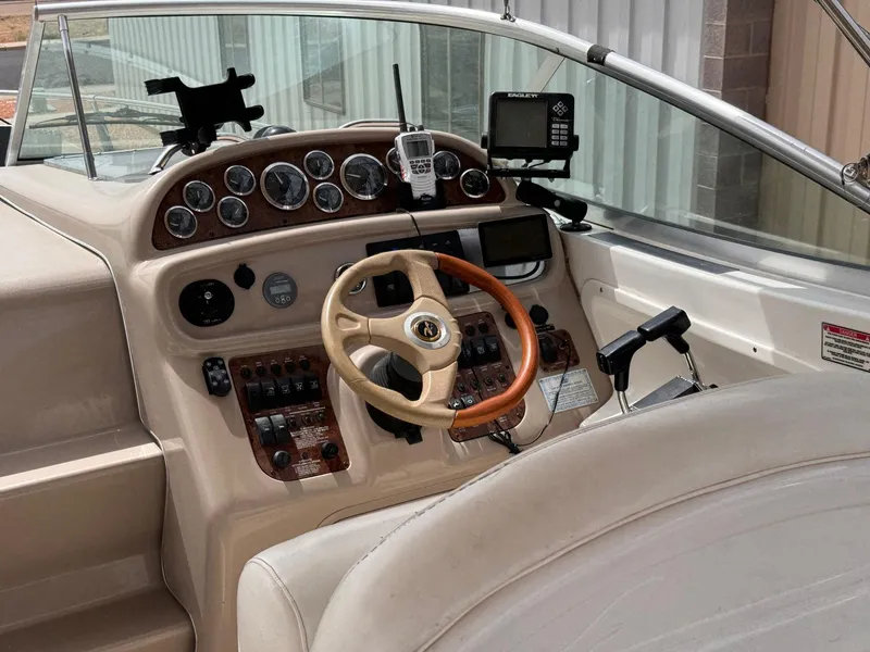 Slide: The Image of 2001 Sea Ray 270 Sundancer helm with gauges, steering wheel, and navigation equipment. - 19