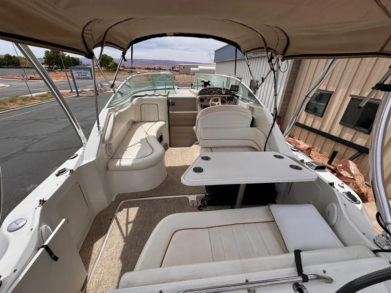 Slide: The Image of 2001 Sea Ray 270 Sundancer boat interior with seating and helm, docked outdoors. - 21