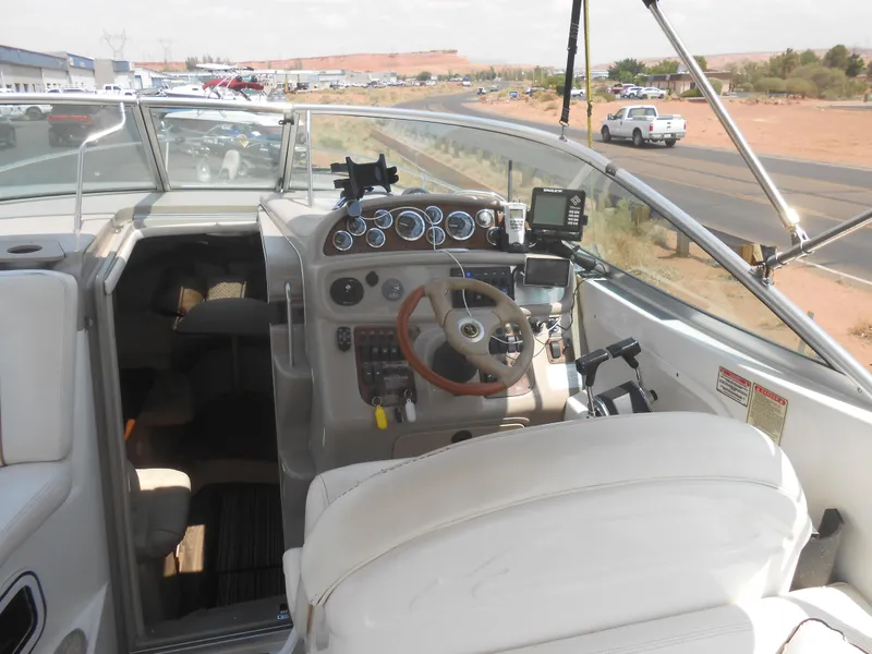Slide: The Image of 2001 Sea Ray 270 Sundancer boat cockpit with steering wheel and control panel. - 25