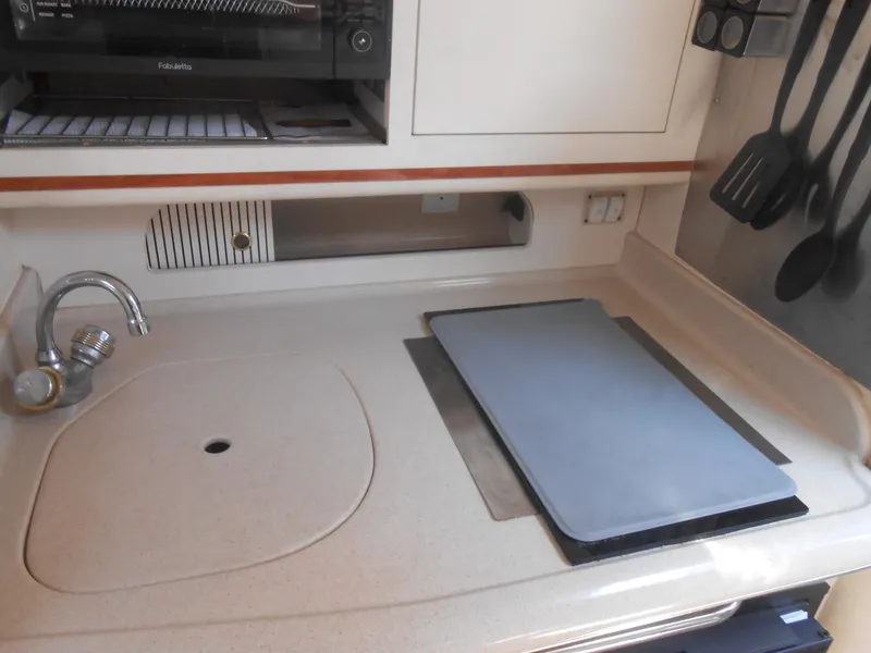 Slide: The Image of 2001 Sea Ray 270 Sundancer galley with sink, stove, and utensils. - 29