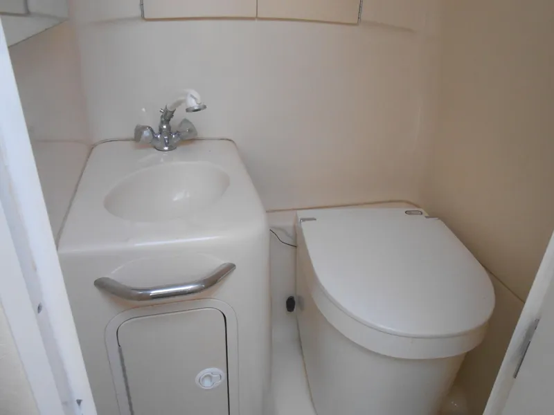 Slide: The Image of Compact bathroom in 2001 Sea Ray 270 Sundancer boat, featuring sink and toilet. - 32