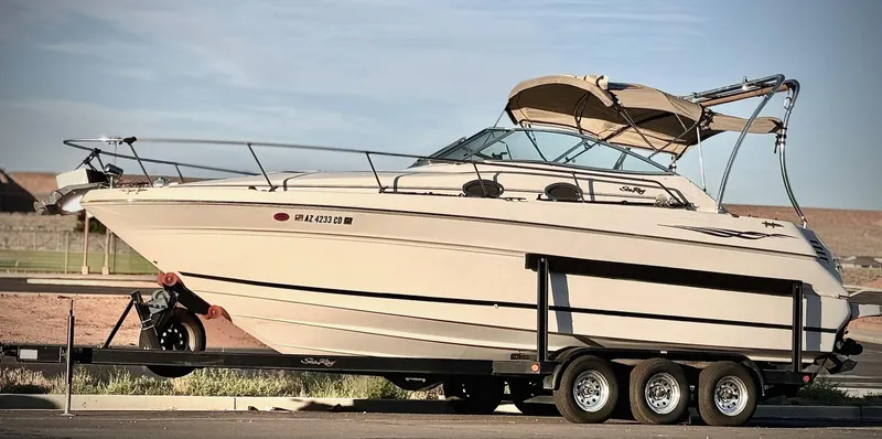 Slide: The Image of 2001 Sea Ray 270 Sundancer boat on trailer, parked outdoors under clear sky. - 5
