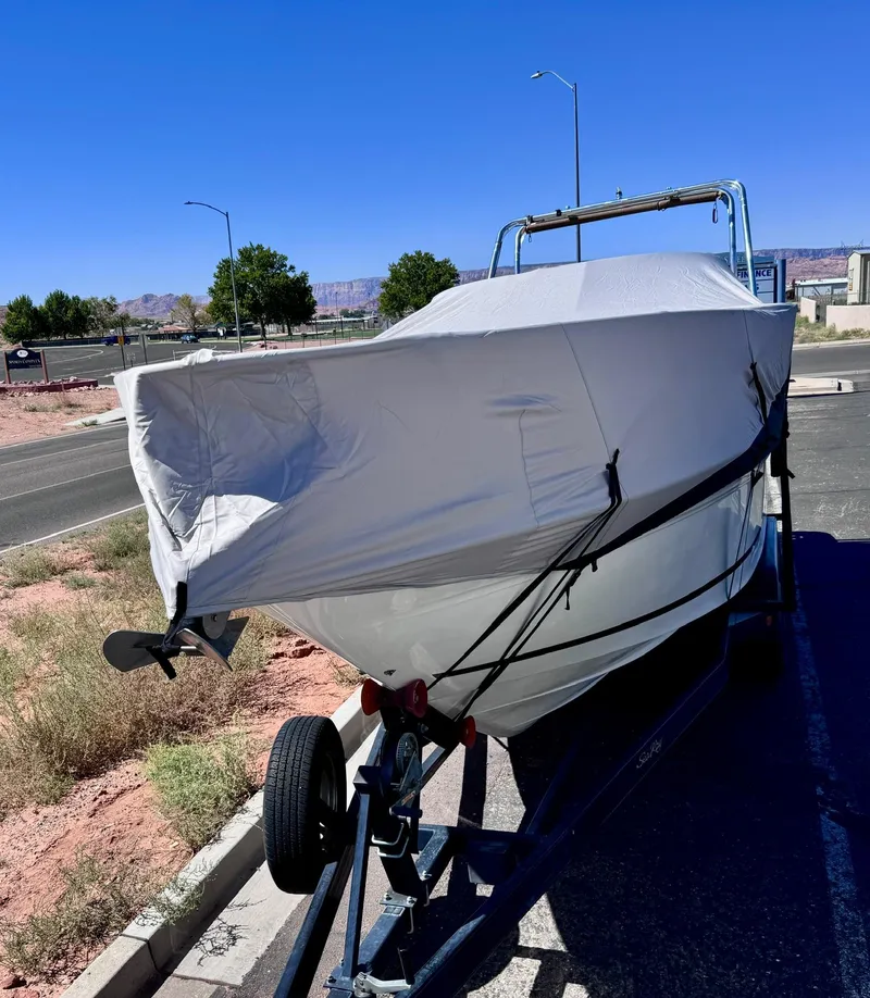 Slide: The Image of Covered 2001 Sea Ray 270 Sundancer boat on trailer, parked roadside under clear blue sky. - 8