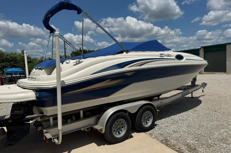 Slide: The Image of 2002 Sea Ray 240 Sundeck boat on trailer under blue sky. - 1