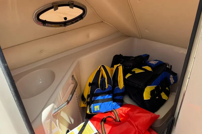 Slide: The Image of Interior of 2002 Sea Ray 240 Sundeck with life jackets and safety gear. - 13