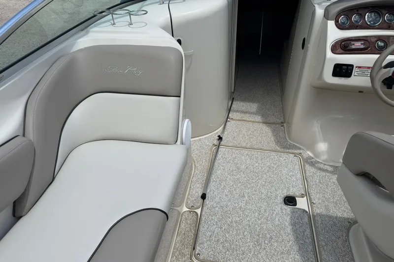 Slide: The Image of Interior of a 2002 Sea Ray 240 Sundeck boat with cushioned seating and control panel. - 14
